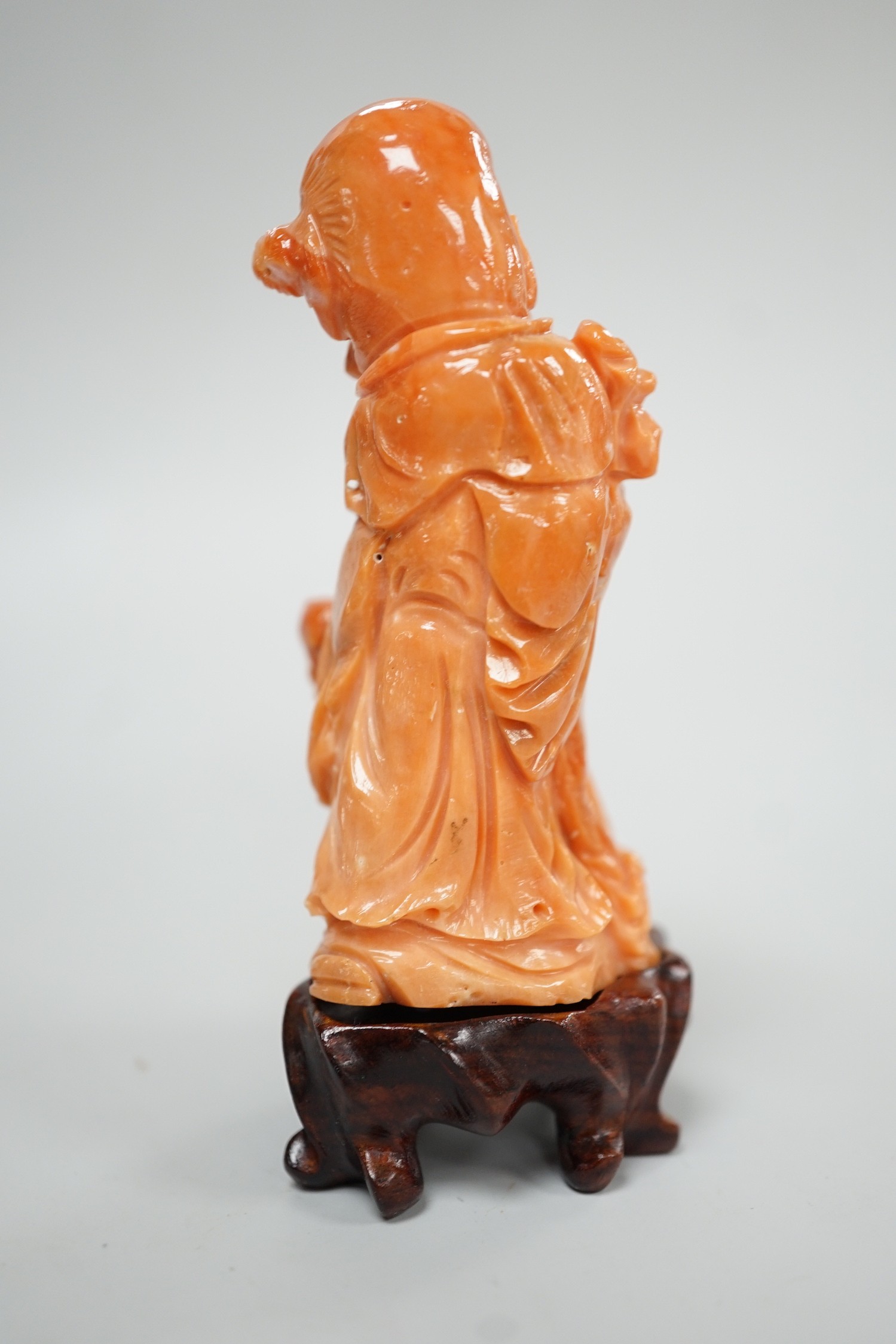 A Chinese coral figure of Shou Lao, 20th century, 7.4 cm high, 73g, wood stand